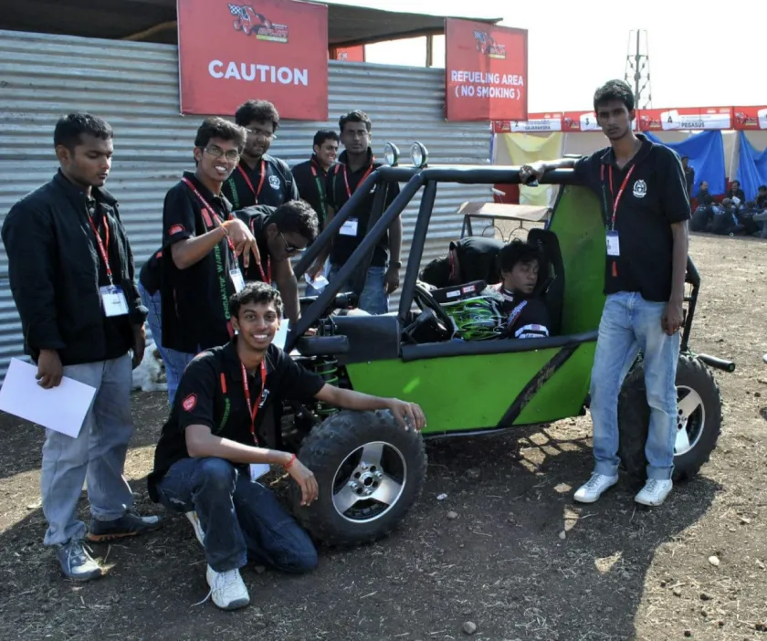 Jason, outlined in red at the left, with teammates around a team-built off-road go-kart at a college engineering competition.